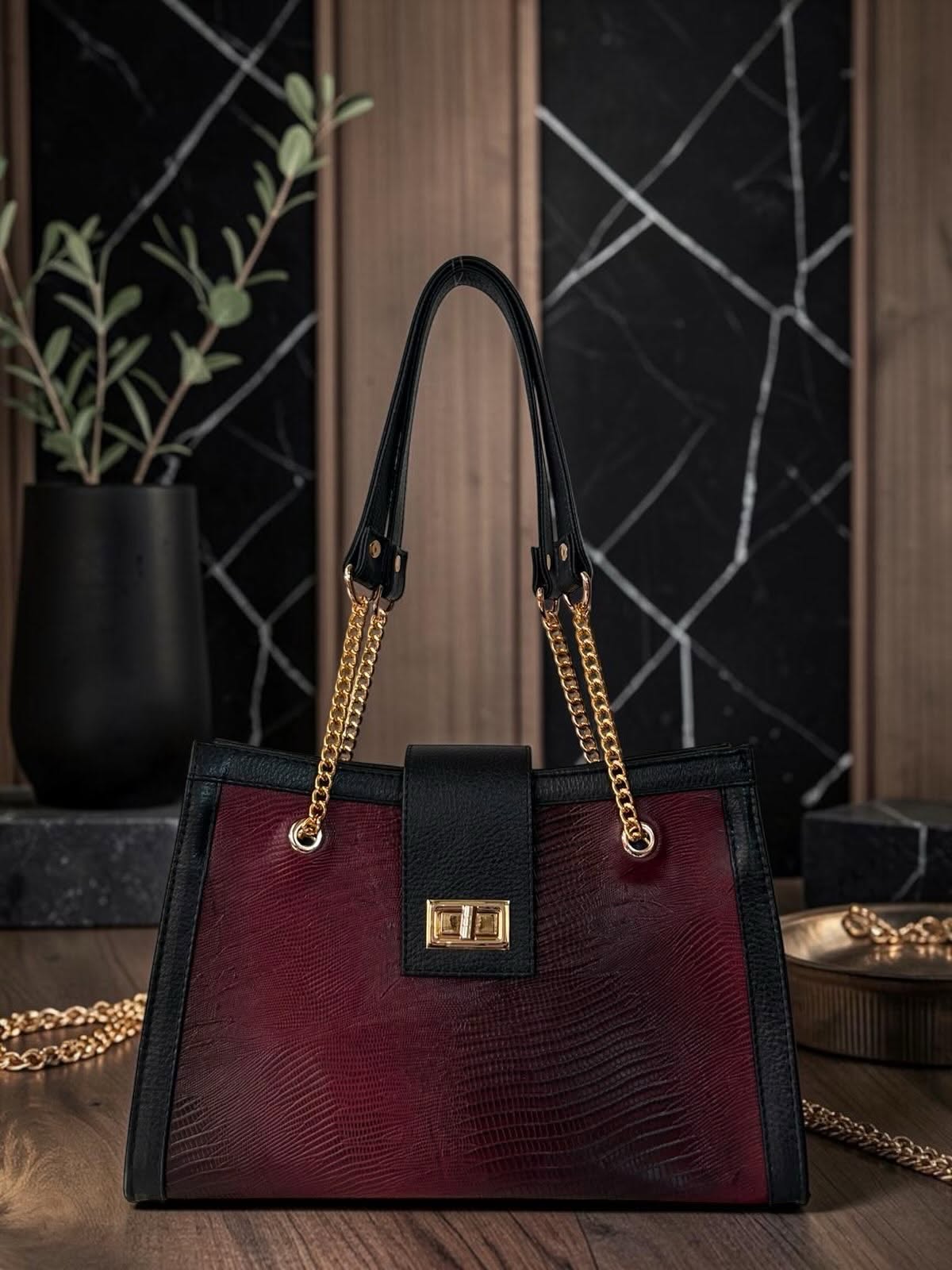Bolsa de piel en tono vino con detalles dorados
