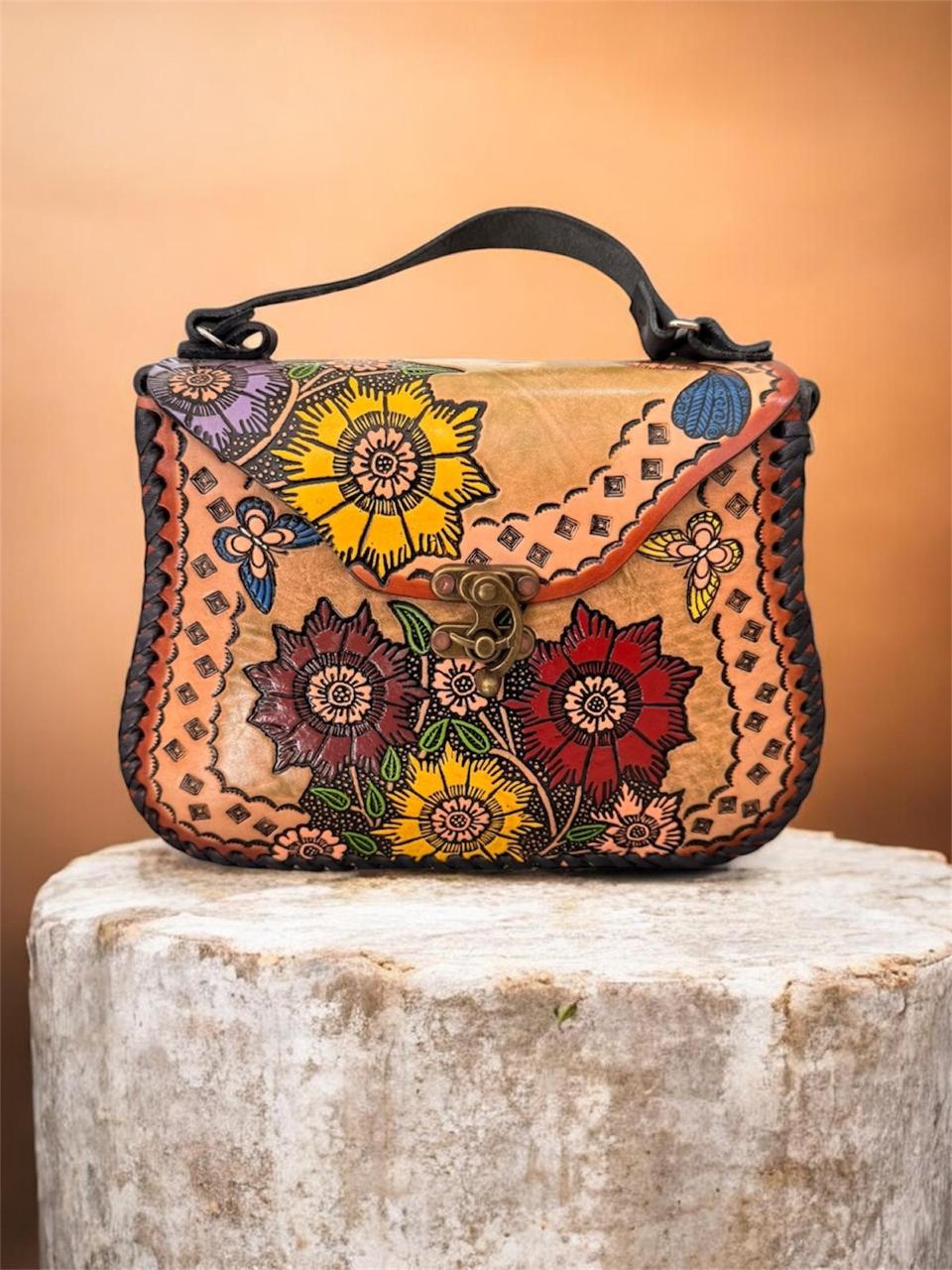 Bolsa artesanal de piel con diseño floral
